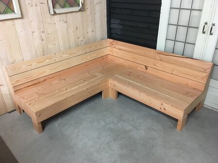 Hoekbank douglas naast een deur tegen een houten wand